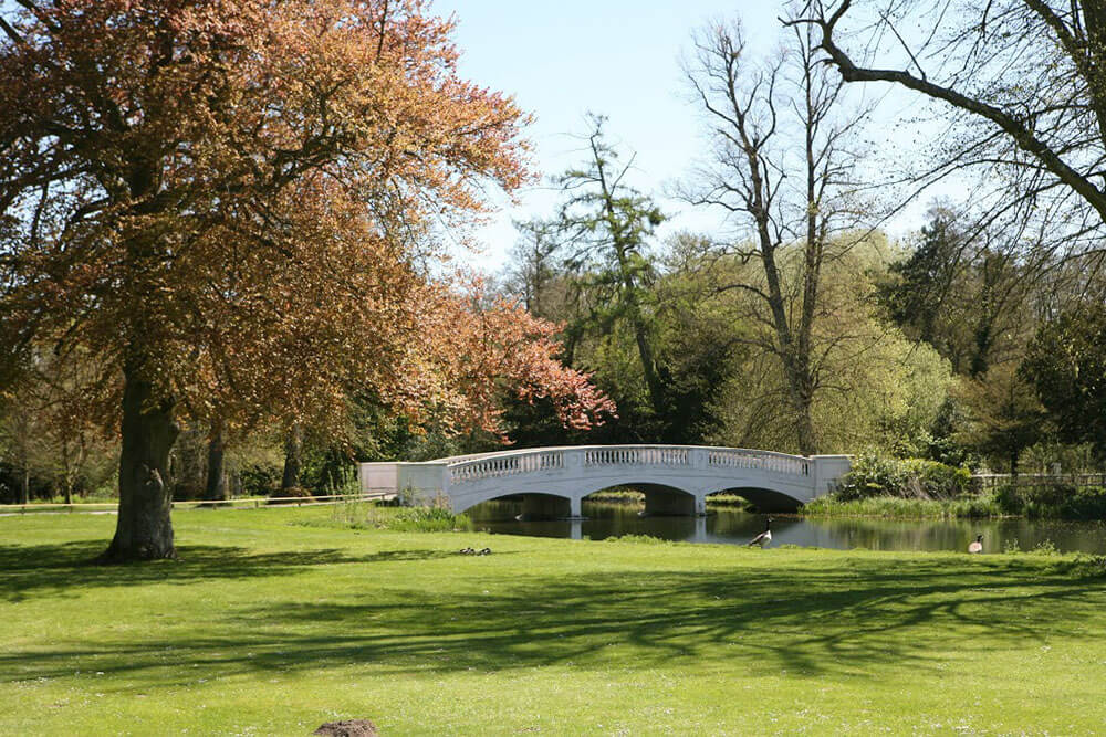 Stunning grounds with river and white bridge at Donnington Grove Hotel an impressive Berkshire Wedding Venue