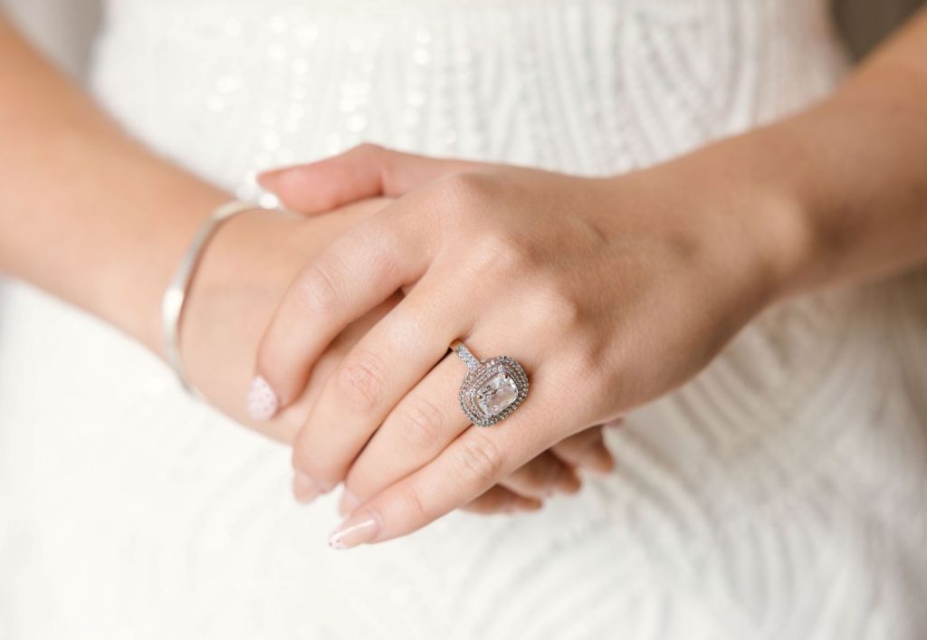 bride showing off engagement ring in wedding photos