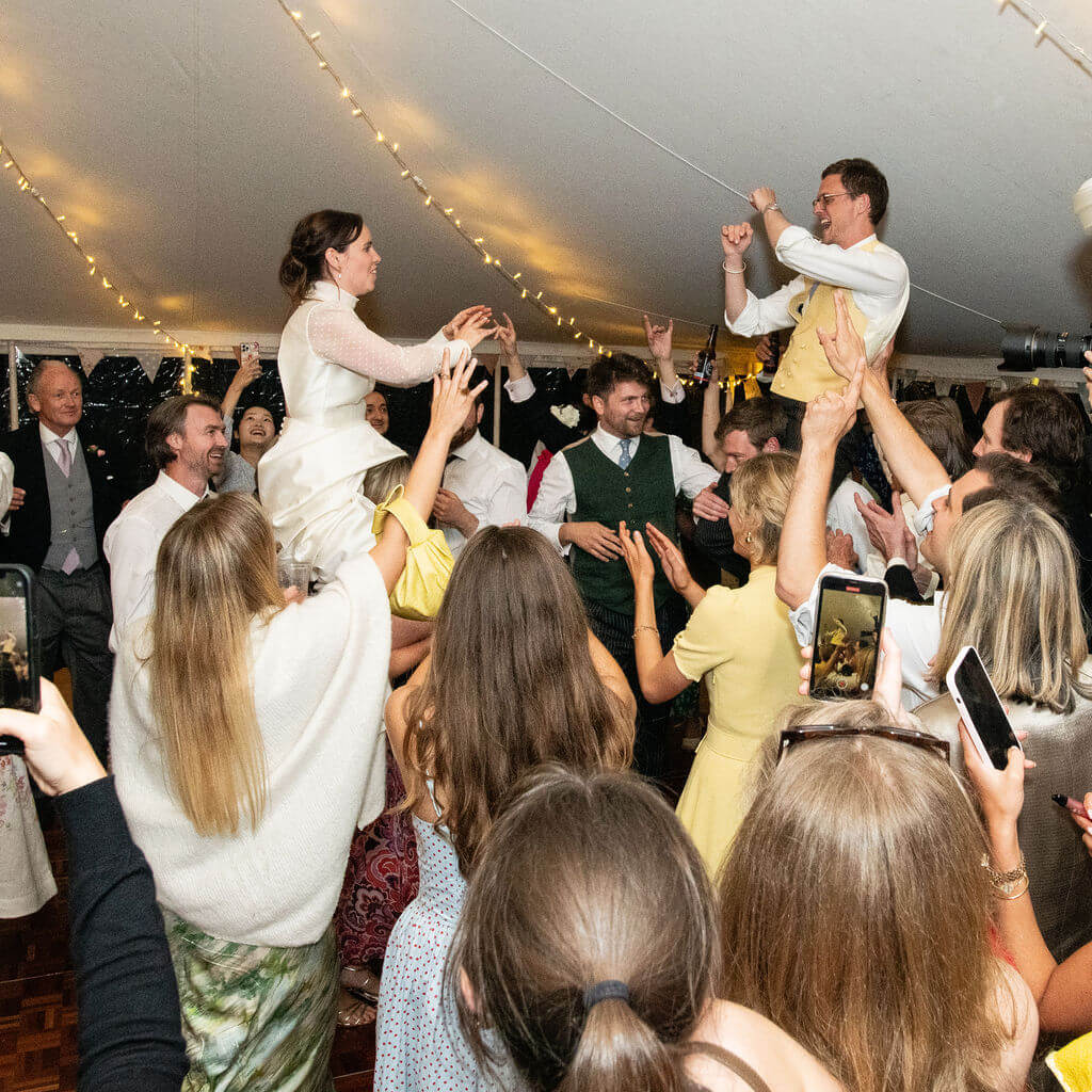 couple dancing on shoulders at marquee wedding How To Plan A Unique Wedding and Be Inspired By Your Friends’ Weddings Without Copying Them
