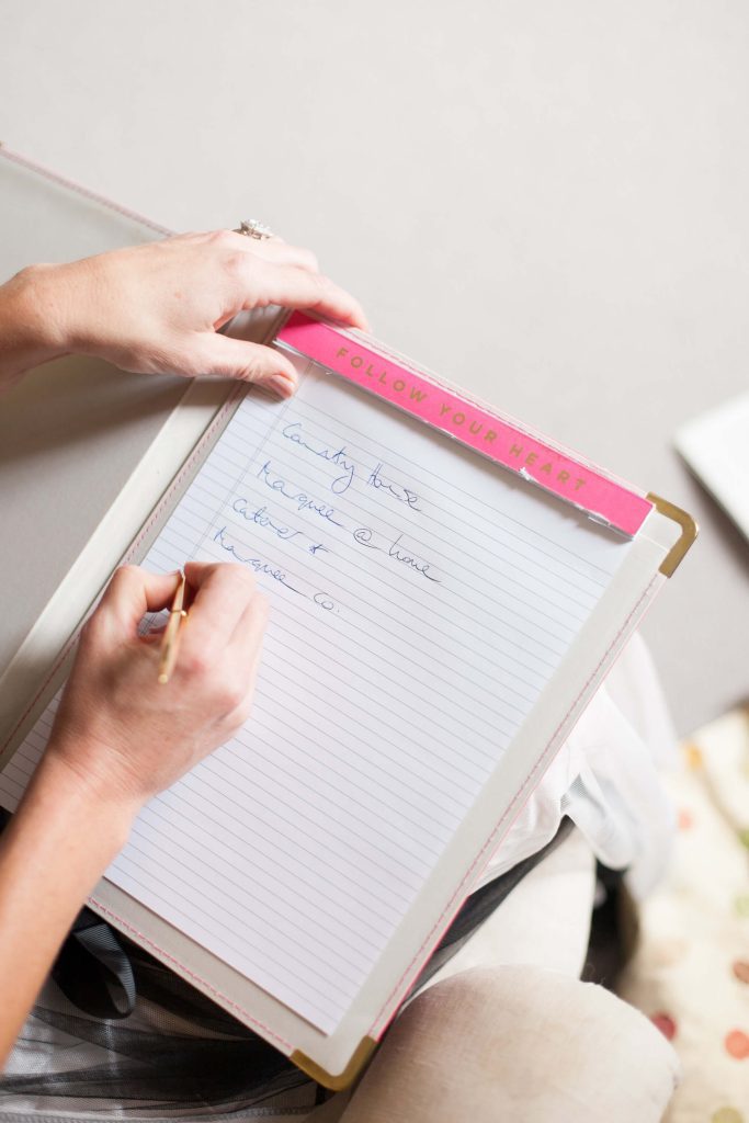 wedding planner using notepad to write notes about planning wedding