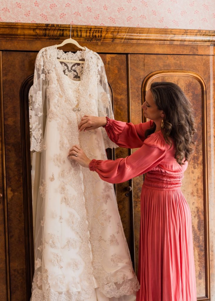 uk wedding planner antonia honour and pop in pink dress hanging wedding gown