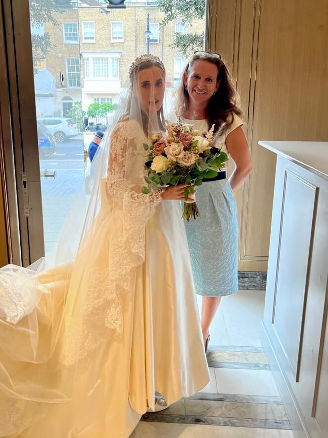 happy bride in long white gown with wedding planner Honour and Pop