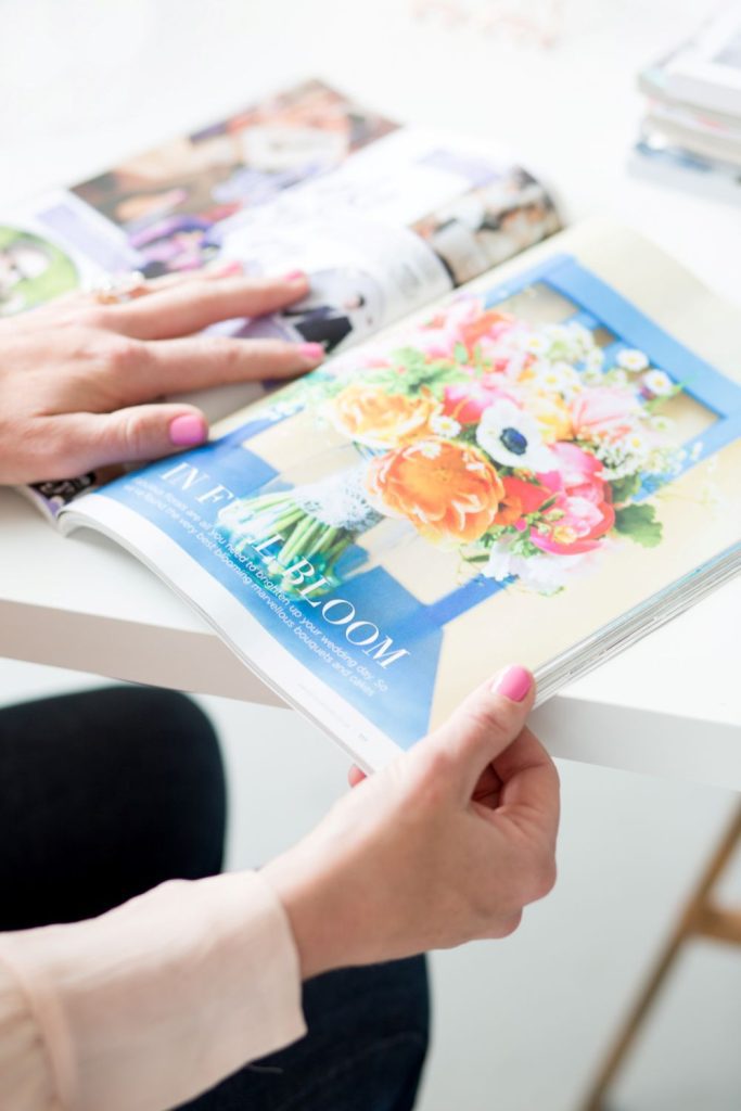 manicured hand browsing wedding magazines to plan a wedding in six months by uk wedding planner