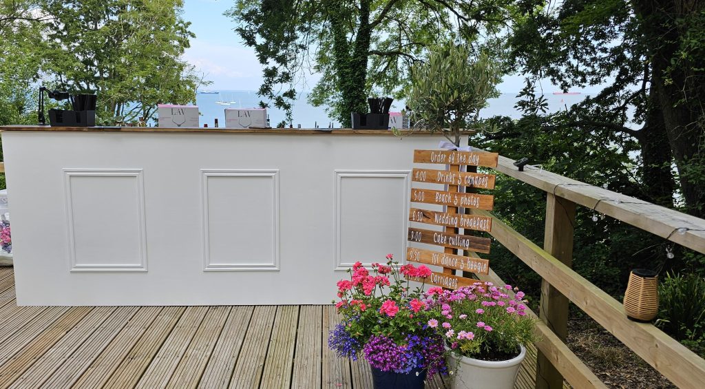 rustic wooden bar priory bay wedding venue isle of wight with rustic signs and flowers