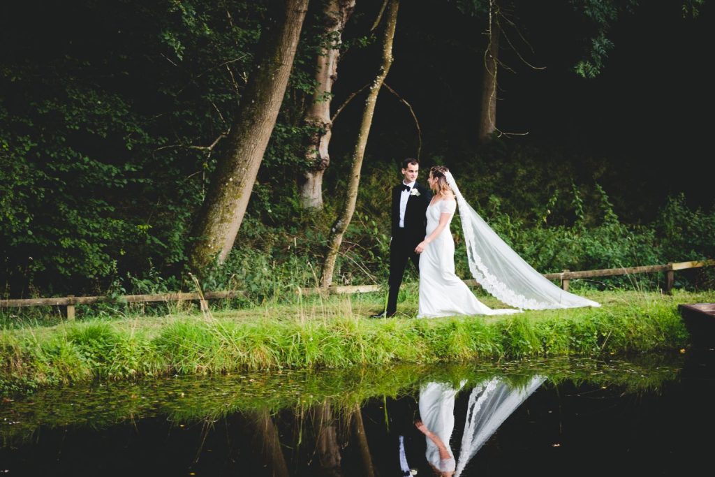 bride and groom walking by water marquee wedding in hampshire