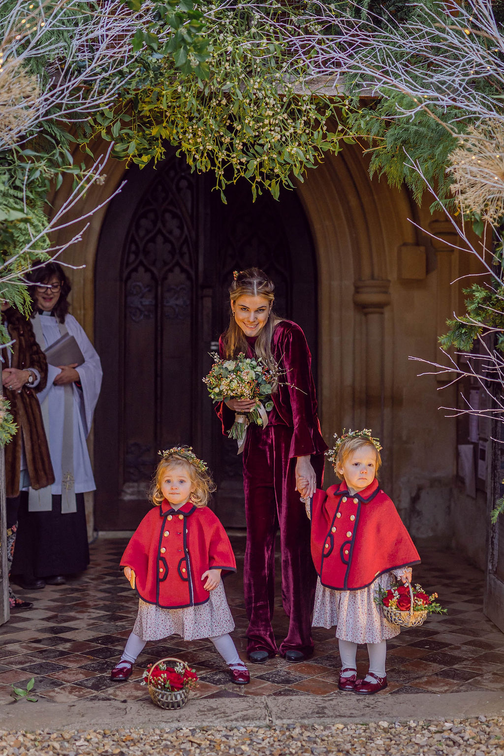 christmas wedding with bridesmaids in velvet and flower girls in red capes berkshire wedding