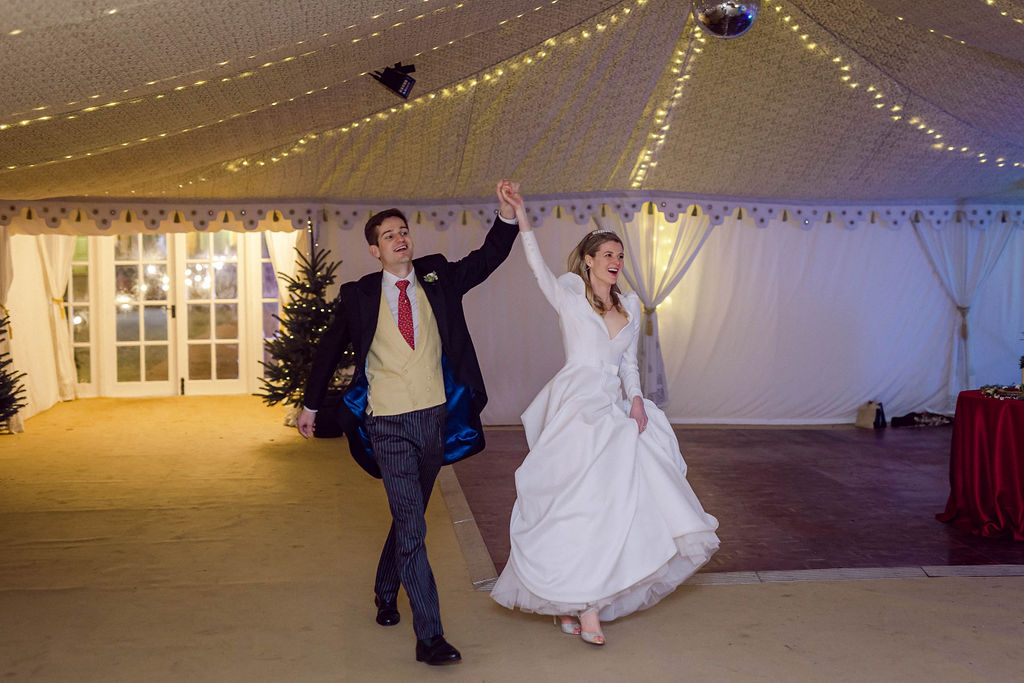 bride and groom entering marquee wedding in Berkshire to greet family and friends