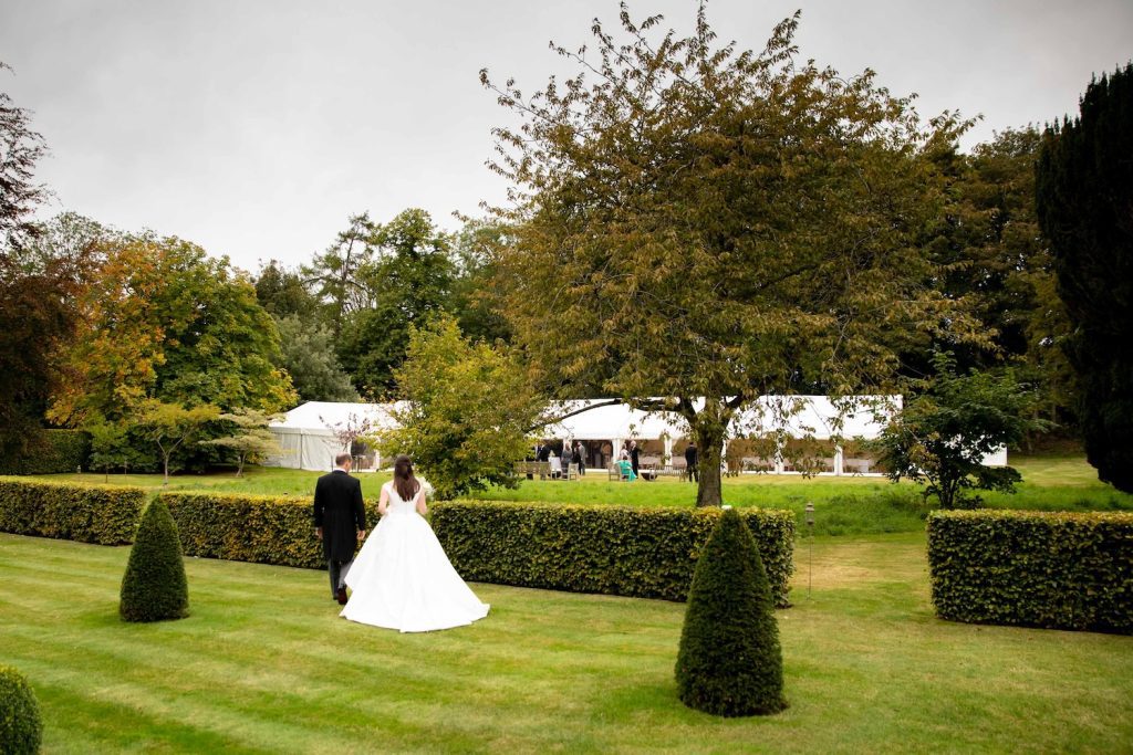 bride and groom walk towards marquee wedding in wiltshire