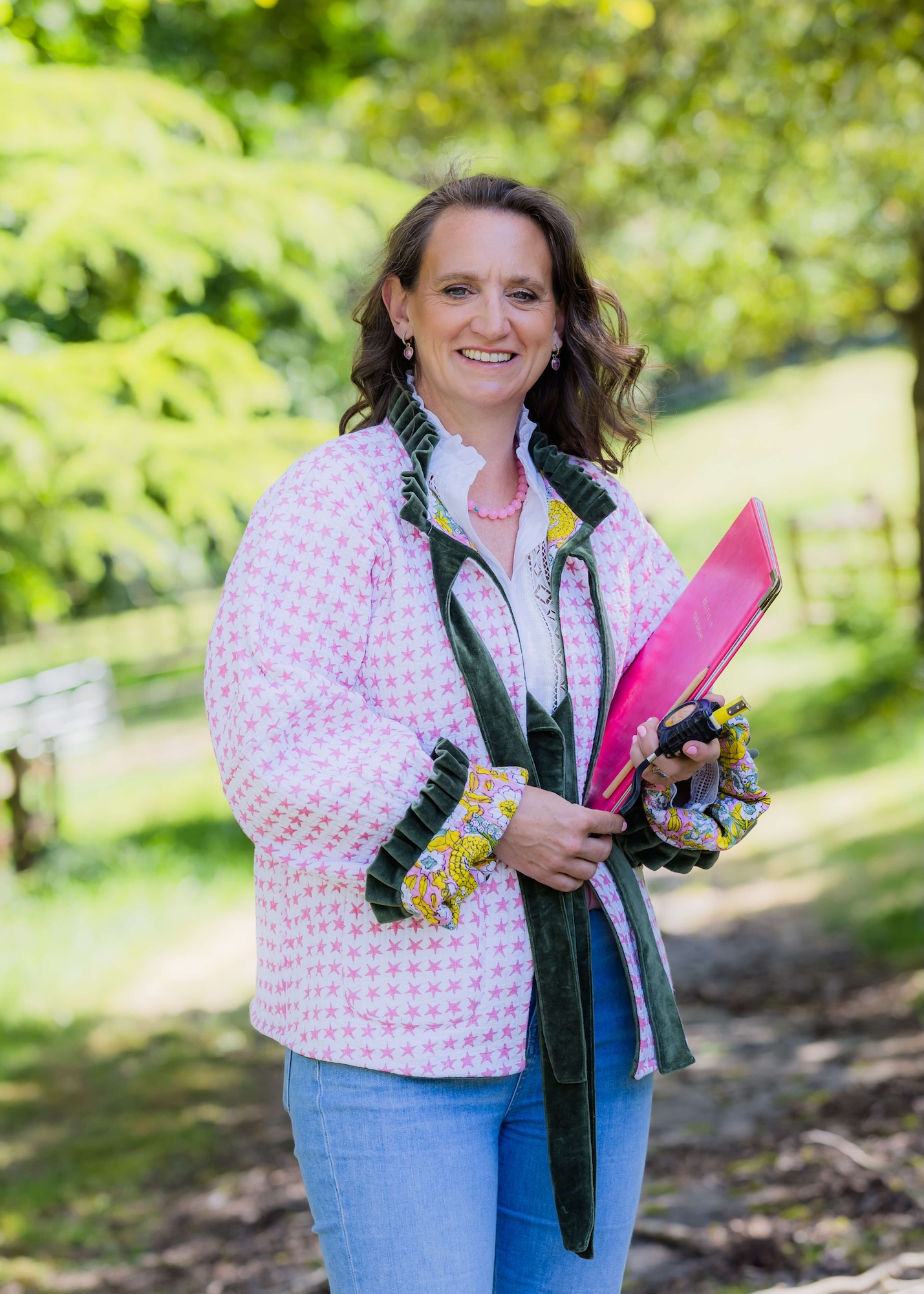 Antonia Roskill marquee and country house wedding planner smiling with pink clipboard