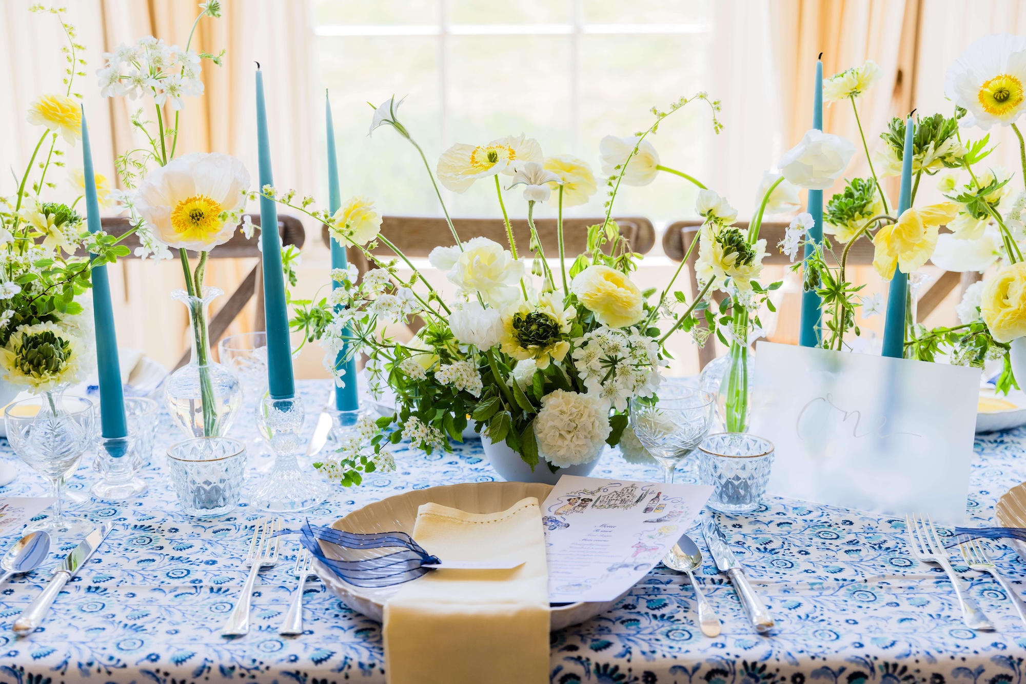 Yellow flowers cut glass blue candles Blue and yellow themed wedding breakfast styled by Honour and Pop.jpg yellow plate with pink ribbon and place setting and pink and yellow flowers for wedding stylist page