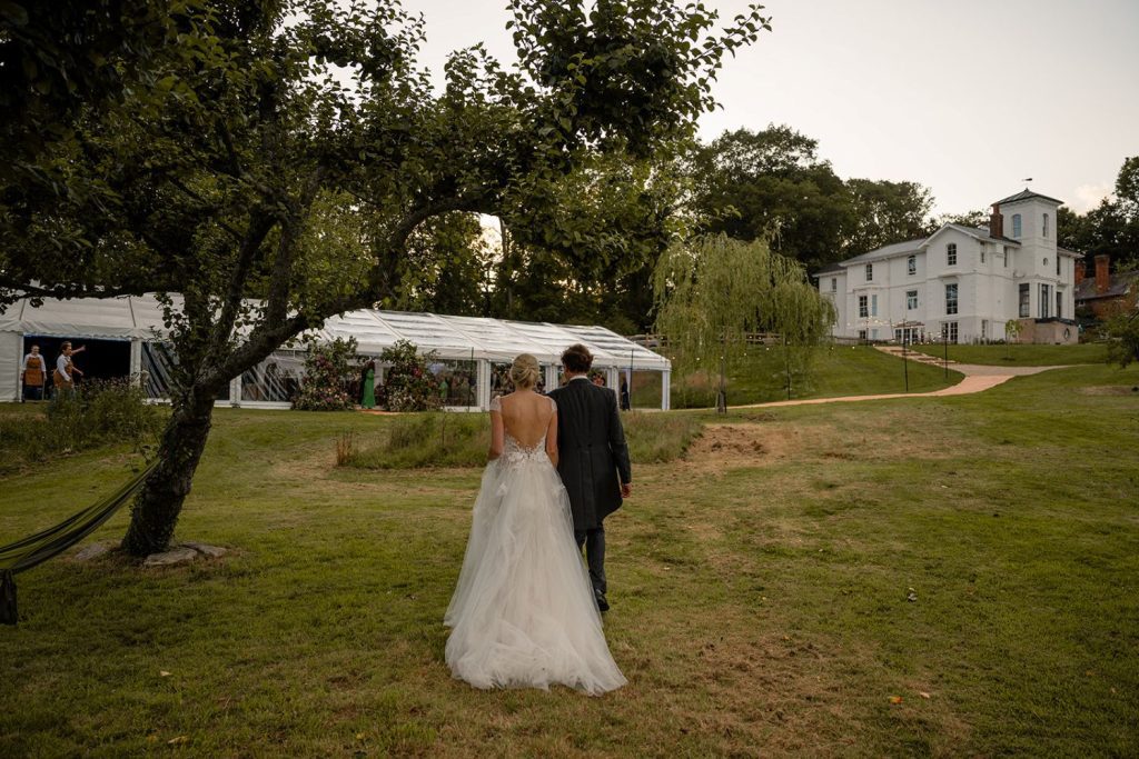 Bride and groom walking to marquee wedding Photography by Helen Abraham
